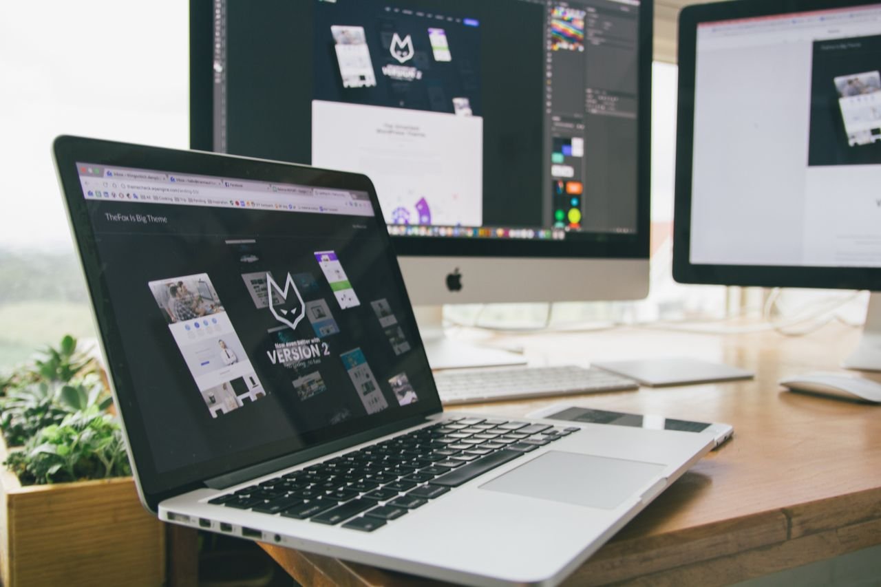 Home A stylish workspace featuring a laptop and monitors displaying design software.