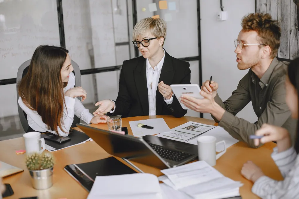 SEO agency team discussing a client strategy together around a conference table