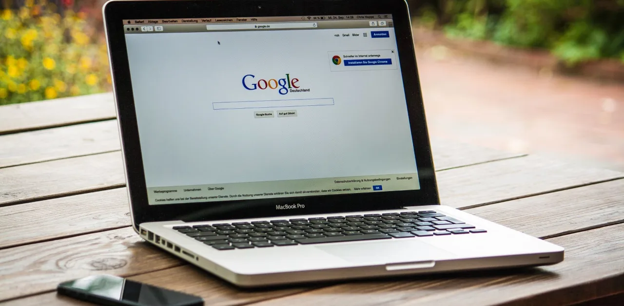 Laptop open to the Google Search home page on a table