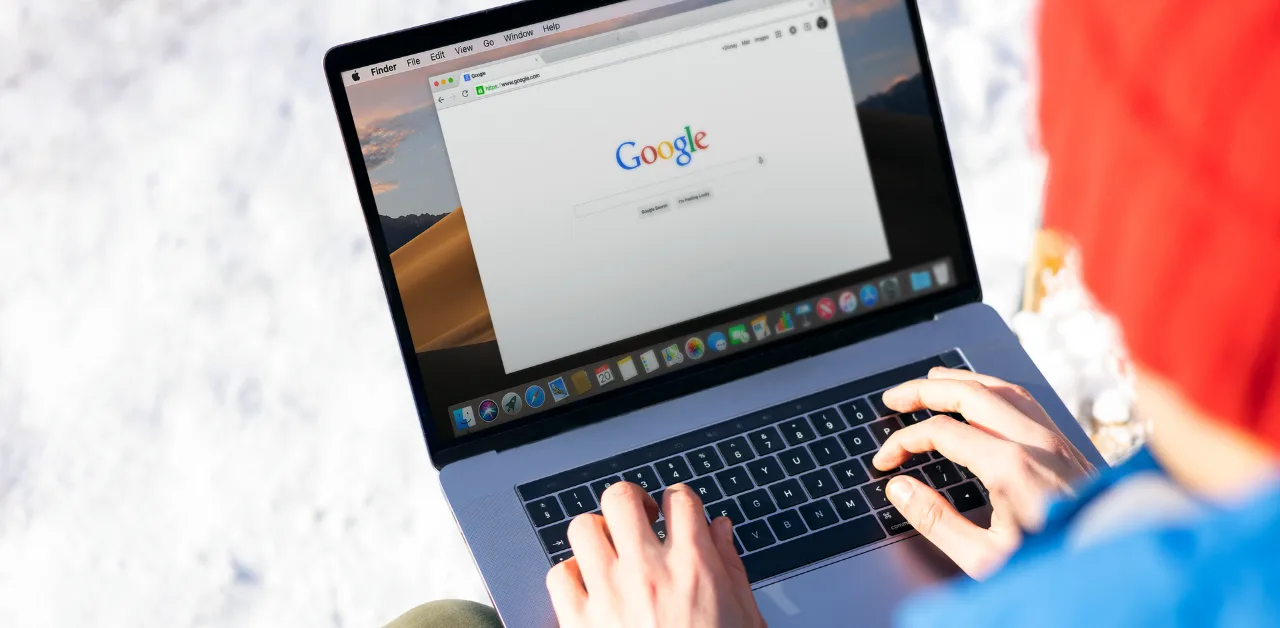 Person searching on Google using a laptop