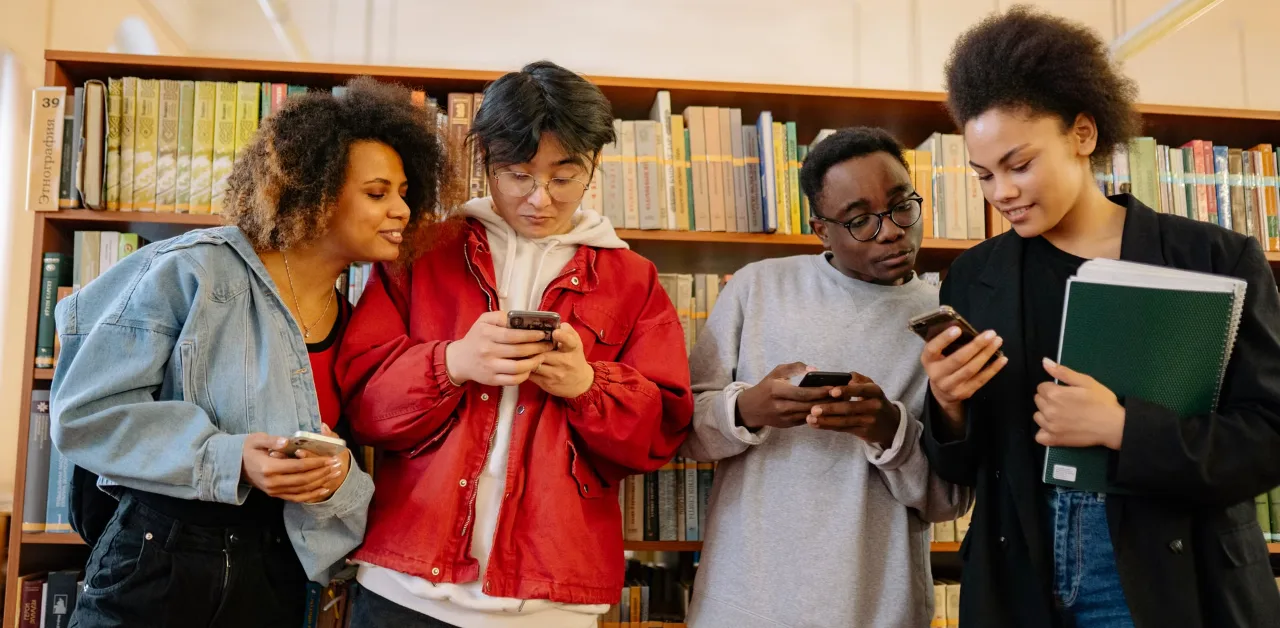 Group of people reading discussions on their smartphones, representing Reddit and Quora answers in AI search