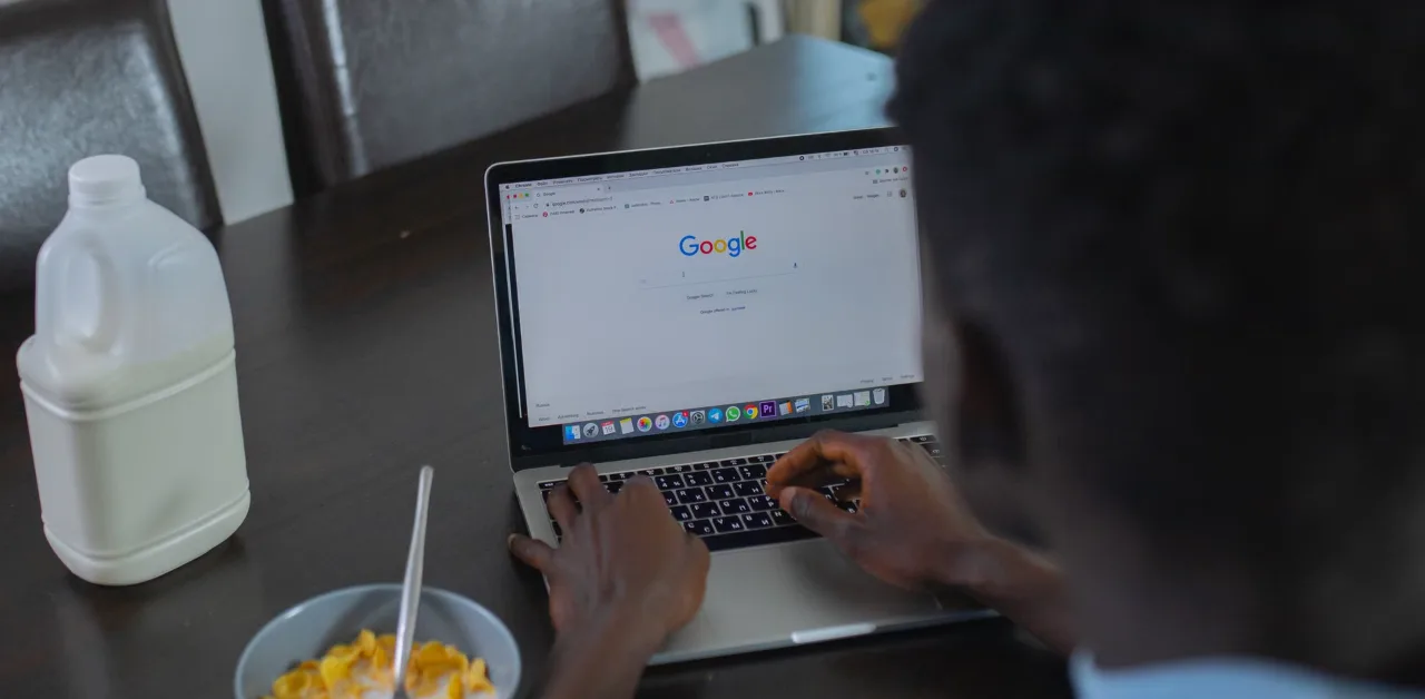 Person using Google search on a laptop, representing traditional SEO and AI answer engine optimization